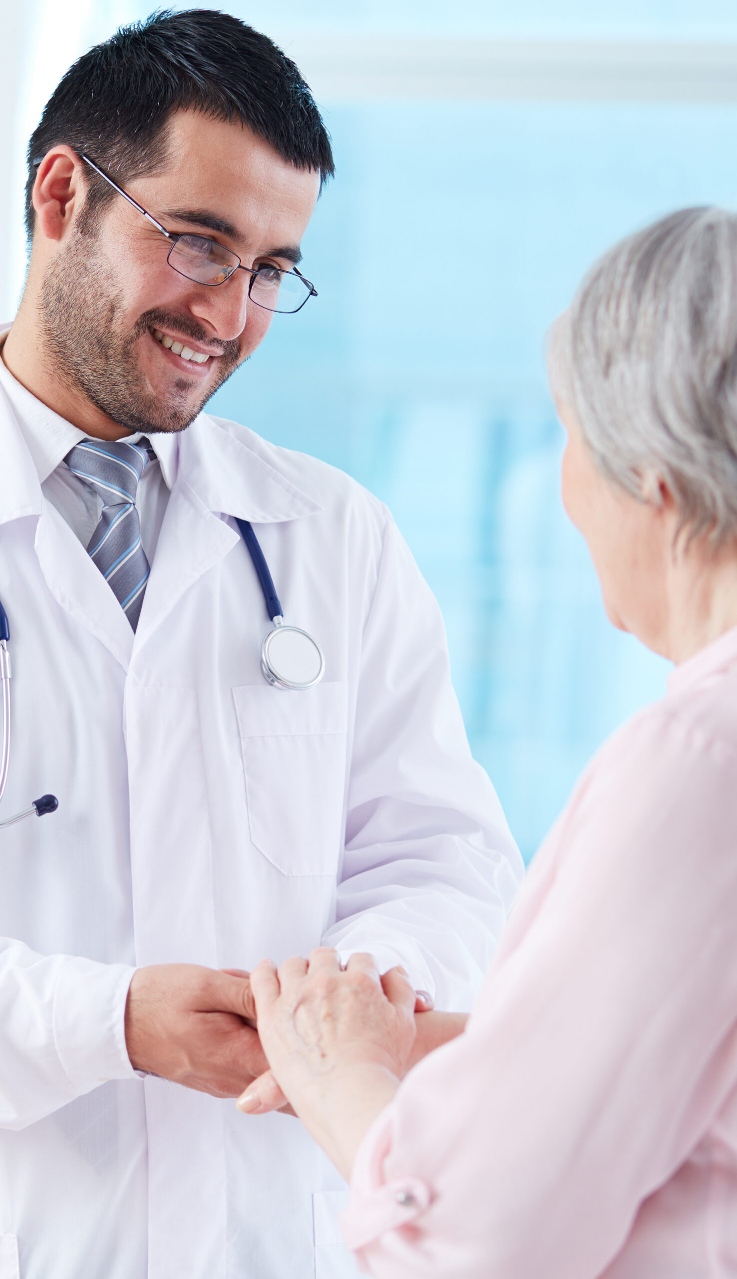 Confident doctor looking at his senior patient while speaking to her